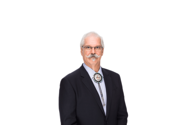 isloated photo of Executive Producer, James Hoagland wearing a suit and bolo tie with glasses and a greying handlebar moustache